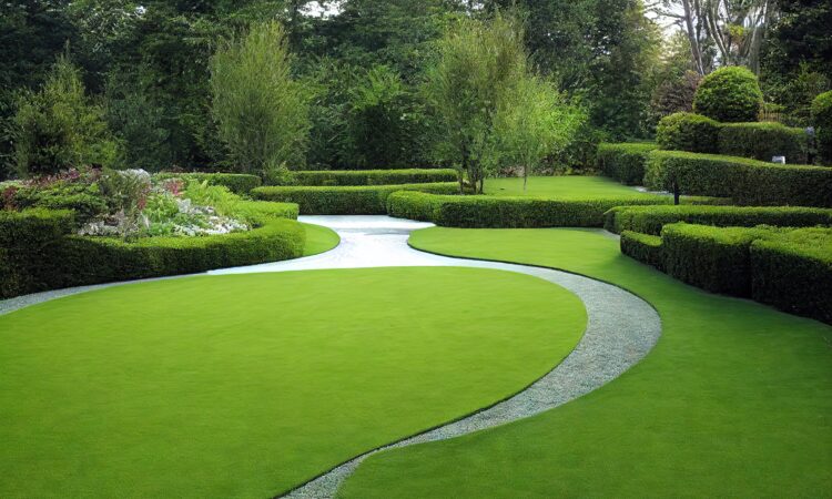 Hyvin hoidettu puutarha, jossa on vihreä nurmikko ja leikatut pensaat.
